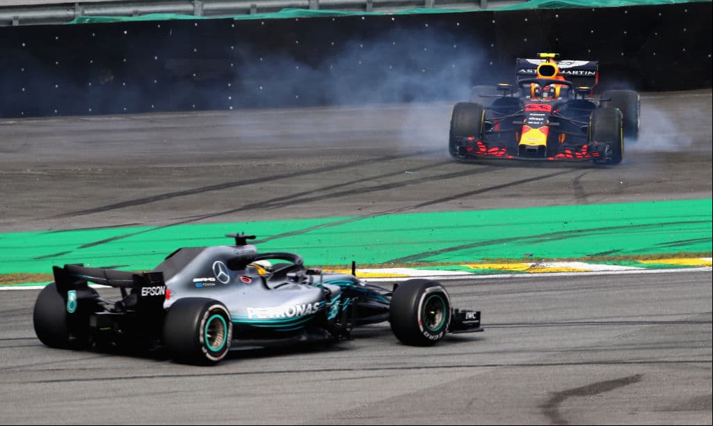Lewis Hamilton aprovecha que el auto de Max Verstappen (derecha) está fuera de la pista para tomar el primer lugar de la carrera.